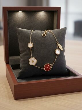 Elegant Gold Chain Bracelet with White Flower and Red Accent